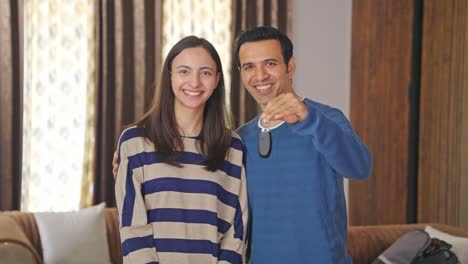 Glückliches-Indisches-Paar,-Das-Der-Kamera-Neue-Autoschlüssel-Zeigt