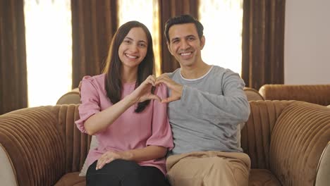 Happy-Indian-couple-making-heart-sign