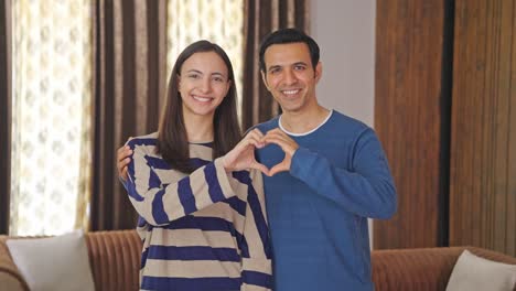 Cute-Indian-couple-making-heart-gesture
