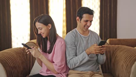 Happy-Indian-couple-busy-in-their-phones