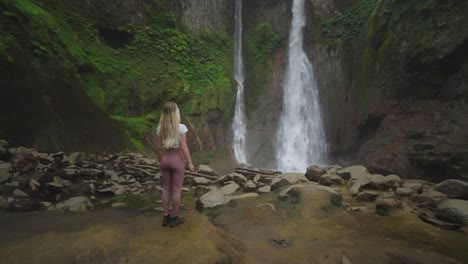 Fit-blond-woman-visiting-Catarata-Del-Toro-waterfall-in-old-volcano-crater
