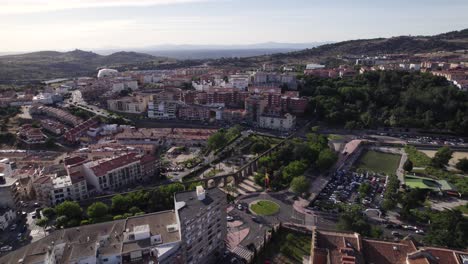 Aerial-view-circling-above-Plasencia-aqueduct-on-the-outskirts-of-the-walled-market-city-with-mountain-landscape-in-the-distance