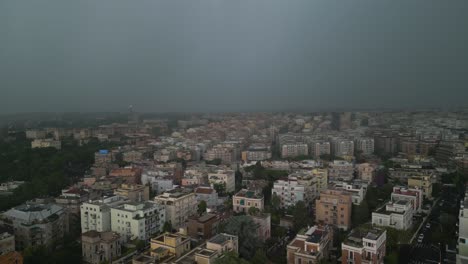 Aerial-drone-backward-moving-shot-over-residential-buildings-with-dark-clouds-and-lightning-striking-over-the-city-of-Rome-in-Italy