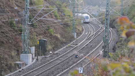 Telephoto-view-of-German-ICE-train-driving-through-countryside,-static-shot