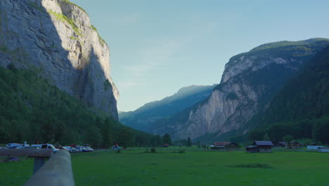 Green-grass-meadow-and-mountain-walls-of-Lauterbrunnen-valley-in-sunlight-and-shadow-panorama
