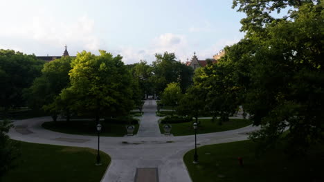Drone-shot-over-students-walking-in-the-parks-of-the-University-of-Chicago,-sunny-evening-in-USA