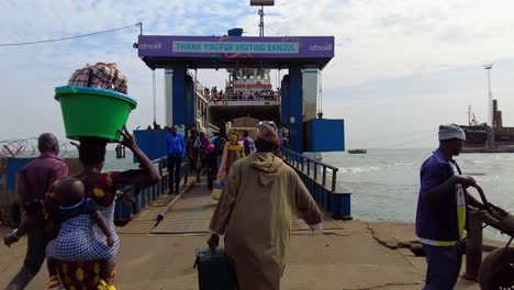 Wide-angle-view-of-people-and-vehicles-boarding-the-Kunta-Kinteh-ferry-at-Banjul-Ferry-Terminal-Gambia-Ports-Authority-crossing-to-Barra,-North-Bank-Region-FPV-POV