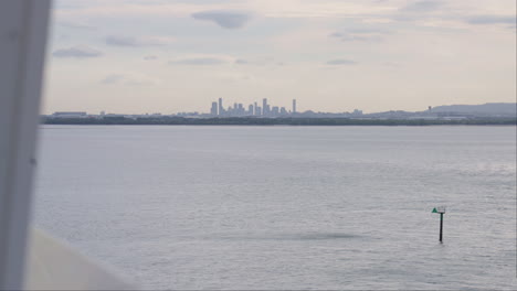 Brisbane-City-Skyline-On-Horizon-View-From-Cruise-Ship-Sailing-Away,-4K-Slow-Motion
