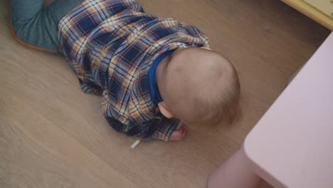 Baby-Spielt-Mit-Einem-Teil-Eines-Medizinischen-Werkzeugs,-Das-Auf-Dem-Boden-Kritzelt