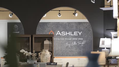 Una-Amplia-Toma-Panorámica-De-Una-Pared-De-Marca-De-Negocio-De-Una-Tienda-De-Muebles-Ashley-Duerma-Mejor-Esta-Noche-Dentro-De-Una-Tienda-Minorista-De-Muebles-En-Chicago