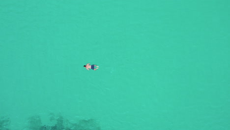 Aerial-View-Of-AMan-Swimming-in-the-Calm-Ocean-near-Playa-del-Trench,-Mallorca,-Spain