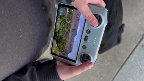 Portrait-Vertical-9:16-aspect-ratio-social-media-TikTok-style-clip-of-Little-kid-boy-or-girl-flying-drone-at-wide-open-park-as-focus-is-on-small-child-tiny-hands-and-big-black-dog-lab---in-4K-60fps