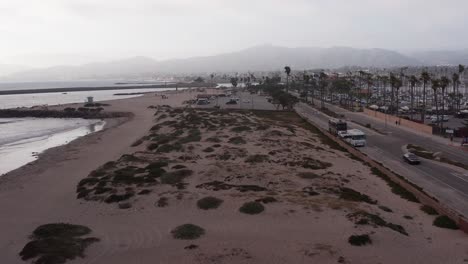 Low-aerial-shot-flying-over-sand-dunes-towards-the-Channel-Islands-National-Park-Visitor-Center-in-Ventura,-California