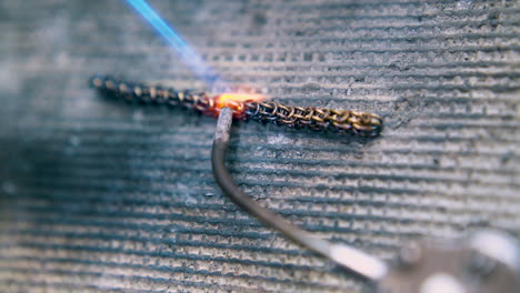processing-of-chain-part-with-tool-and-gas-burner-closeup