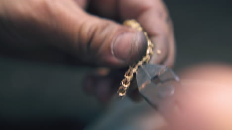 jeweler-removes-leftovers-from-chain-with-pliers-closeup