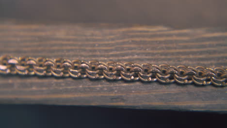 goldsmith-grinds-chain-with-rasp-on-wooden-gutter-close-view