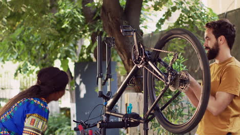 Sporty-couple-repairing-bicycle-outdoor