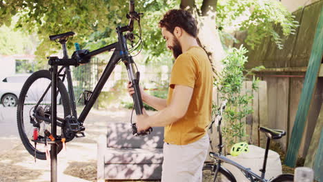 Man-adjusting-bicycle-parts-outside