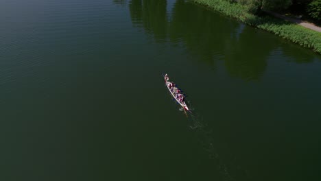 Dragon-boat-swimming-on-a-lake,-drone-shot