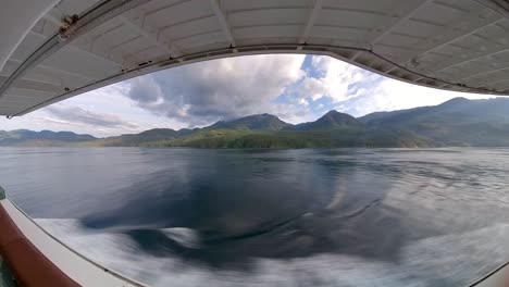 On-a-cruise-ship-balcony-watching-the-Alaskan-coast,-mountains,-and-Tongass-forest-pass-by---wide-angle-hyper-lapse