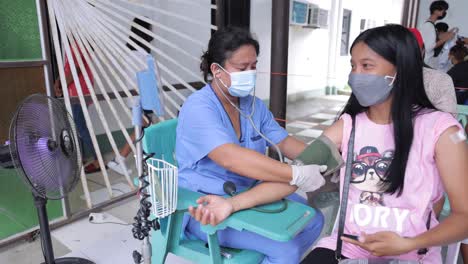 Asiatische-Krankenschwester-Untersucht-Patienten,-Der-Den-Blutdruck-Misst