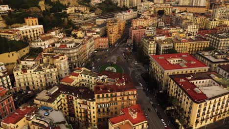 Aerial-top-down-shot-showing-traffic-on-roundabout-in-old-town-of-Naples-during-golden-sunset