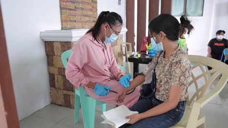 Asiatische-Krankenschwester-überprüft-Den-Blutdruck-Des-Patienten