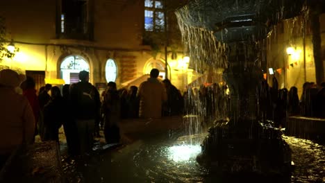 Nighttime-tilt-up-of-an-illuminated-fountain-at-Freedom-of-the-Press-Square-in-the-Concha-y-Toro-Neighborhood,-visitors-enjoying