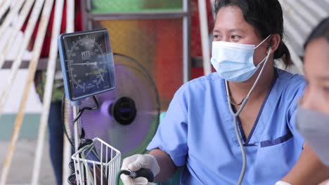 Enfermera-Asiática-Que-Usa-Una-Máquina-De-Presión-Arterial