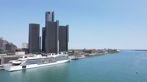 Viking-Octantis-cruise-ship-docked-in-front-of-the-Renaissance-Center-in-downtown-Detroit,-aerial-view