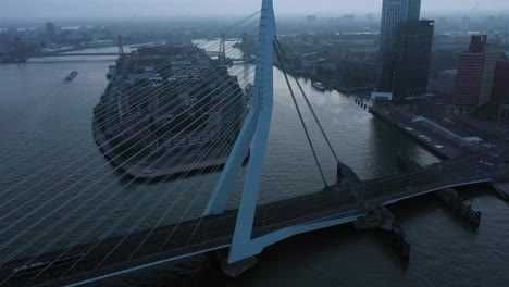 Aerial-approaching-shot-showing-Traffic-on-Erasmus-Bridge-in-Rotterdam-during-cloudy-morning