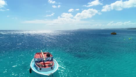 Barco-De-Vela-Anclado-En-El-Agua-Del-Océano-Azul-Profundo-Arenoso-En-El-Día-Ventoso-Del-Cielo-Azul-Brillante