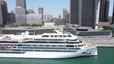 Viking-Octantis-cruise-ship-and-Detroit-city-skyline,-aerial-view