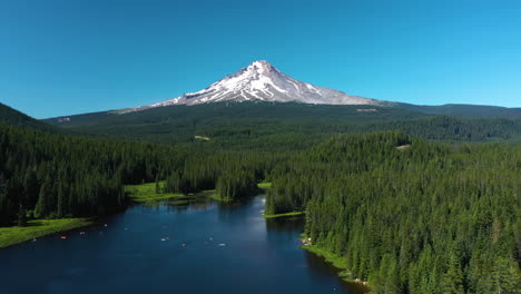 Aerial-view-backwards-over-the-Trillium-lake-with-Mt-Hood-in-background,-summer-in-OR,-USA