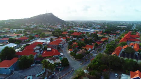 Golden-light-glow-illuminates-hillside-neighborhood-with-red-roofs,-Curacao