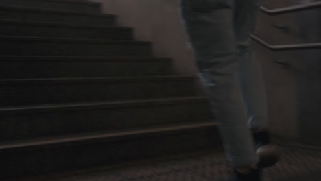 Young-Man-is-Running-up-Stairs-in-Cool-Sneakers-and-Jeans,-Handheld