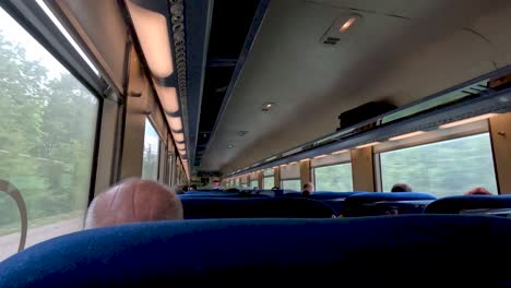 Inside-train-view-with-people-sitting-in-their-seats-traveling-through-Switzerland