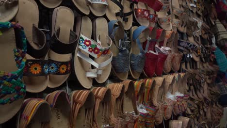 Slow-established-shot-of-multiple-pairs-of-sandals-hanging-for-sale-in-a-shop
