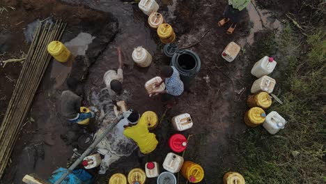Masai-children-collect-drinkable-water-from-well-for-family-and-tribe,-aerial-view