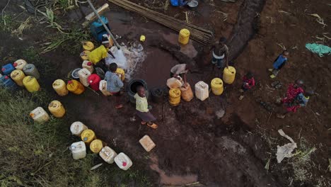 Los-Niños-Africanos-Llenan-Recipientes-De-Plástico-Con-Agua-Dulce-Del-Pozo,-Kenia