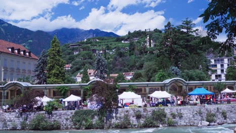 The-monthly-flea-market-in-front-of-the-Wandelhalle-along-the-Winter-Promenade-in-Meran,-South-Tyrol,-Italy