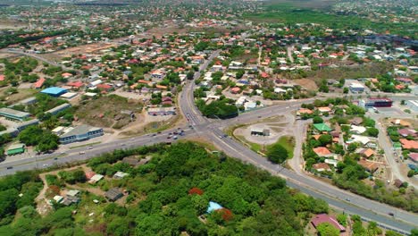Drone-tilt-down-bird's-eye-view-road-intersection-four-way,-curacao-caribbean