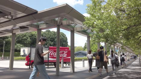 Japaner-Gehen-Im-Sommer-Am-U-Bahn-Eingang-Kokusaikaikan-In-Kyoto,-Japan,-Neben-Einem-Coca-Cola-Lastwagen-Spazieren