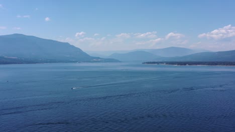 Distant-Journey:-Boat-Gliding-across-Shuswap-Lake's-Serene-Waters