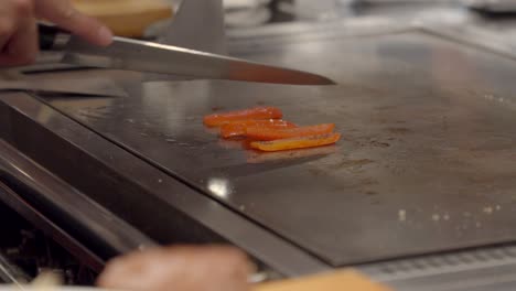 Teppanyaki-Kochkocher-Schneiden-Rote-Gemüsepaprika-über-Einem-Heißen-Tisch-In-Osaka,-Kobe,-Japan,-Authentisches-Erlebnis