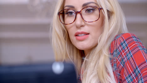 Blond-Woman-with-Glasses-Busy-with-Tablet-Computer