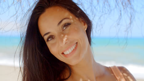 Mujer-Alegre-En-La-Playa-Sonriendo-A-La-Cámara