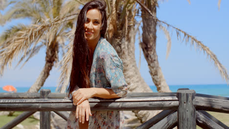 Mujer-Joven-Y-Bonita-Apoyada-En-La-Barandilla-En-La-Playa