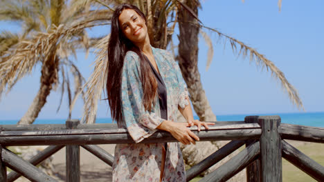 Mujer-Joven-Y-Bonita-Apoyada-En-La-Barandilla-En-La-Playa