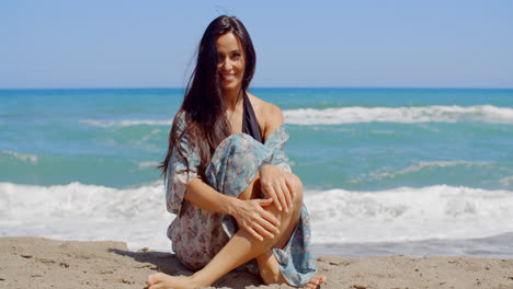 Mujer-Atractiva-Sonriente-Sentada-En-La-Arena-De-La-Playa